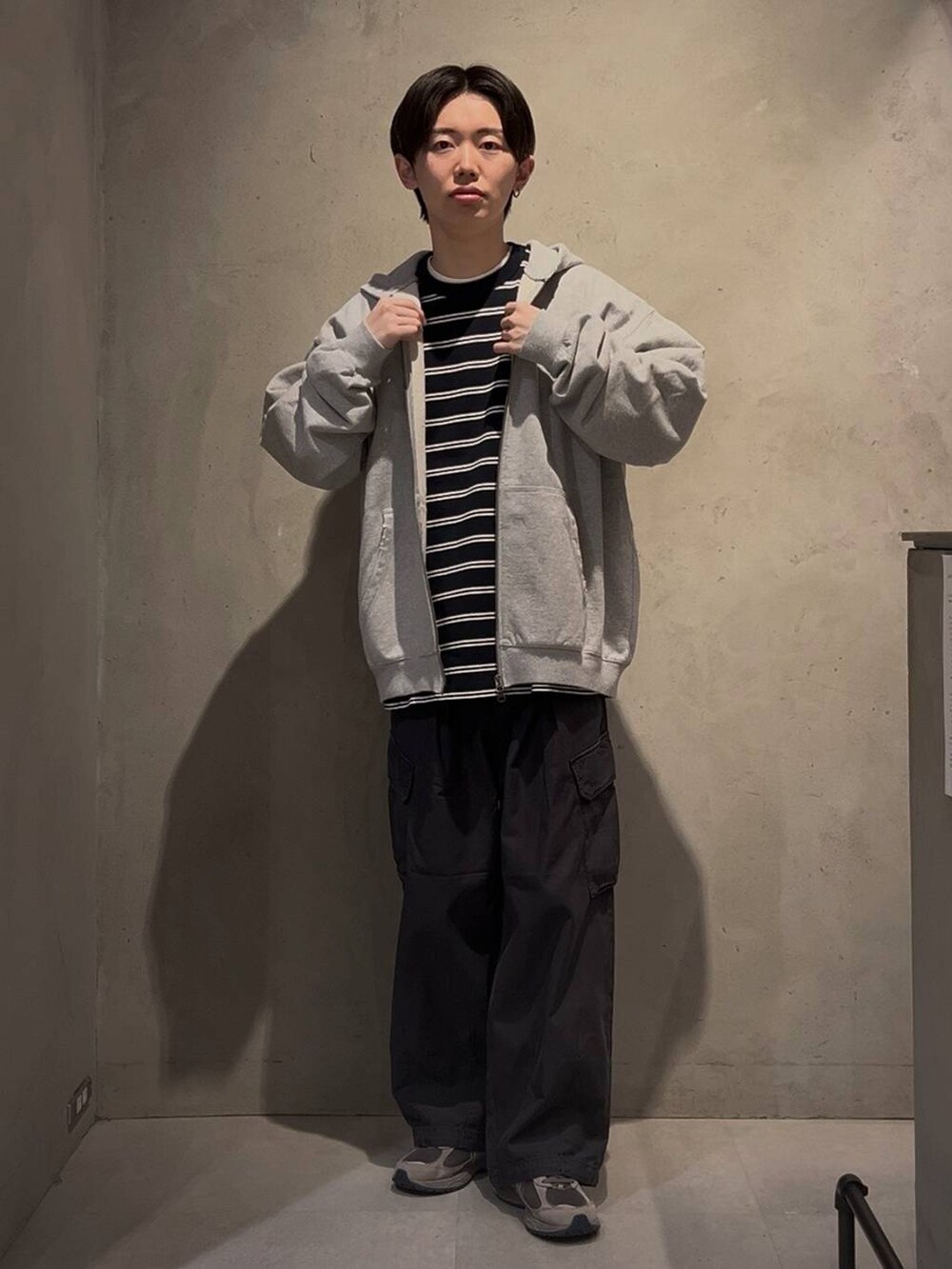 ブラック系のカーゴパンツ、ブルー系のTシャツ/カットソー、グレー系のパーカーを着用したメンズの冬コーディネートの2枚目の写真