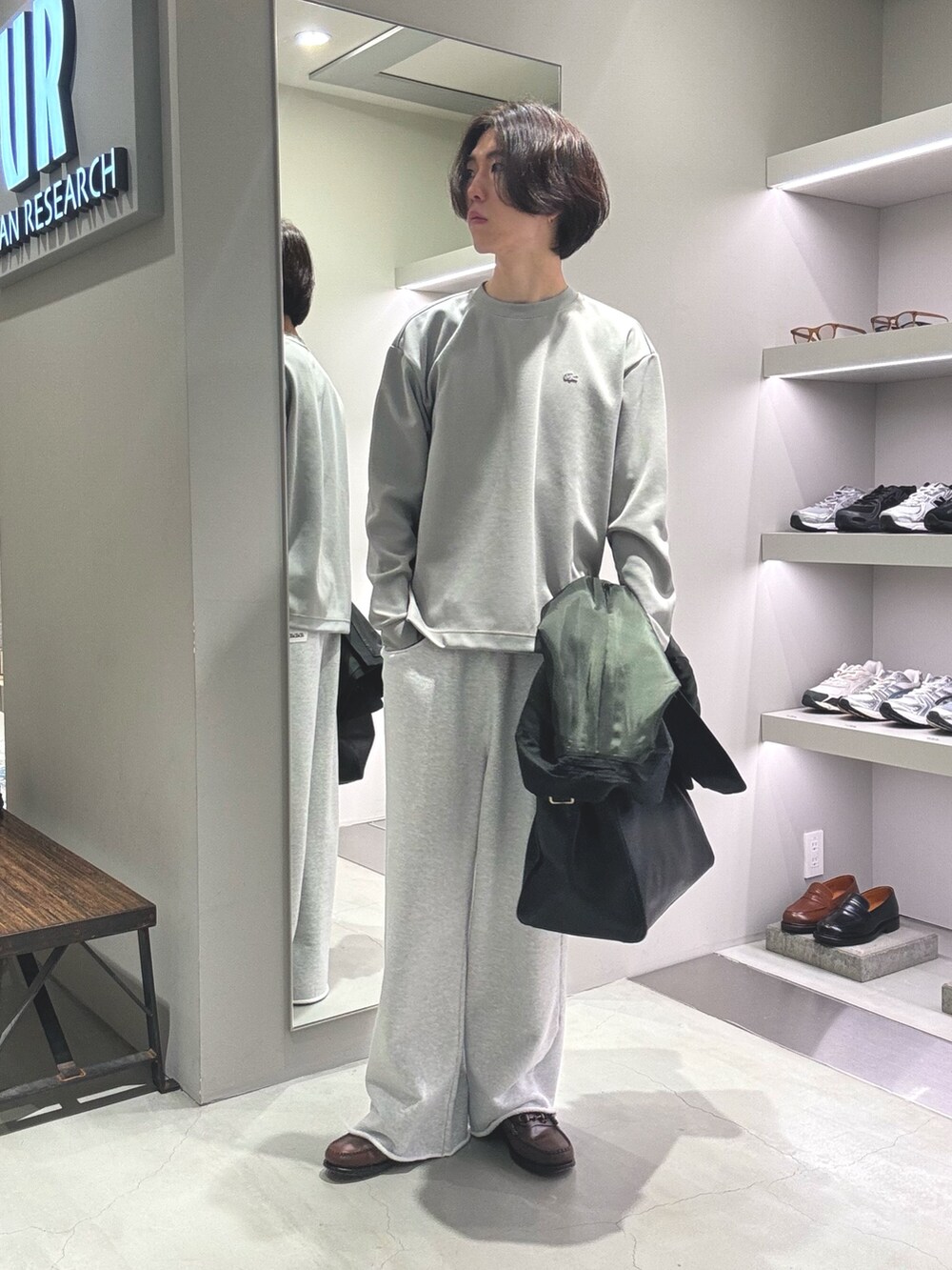 ブラック系のトートバッグ、グリーン系のその他アウター、グレー系のTシャツ/カットソーを着用したメンズの秋コーディネートの2枚目の写真