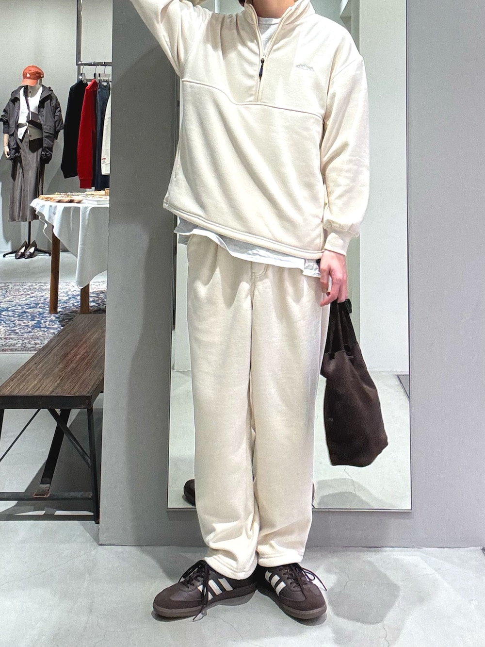 ブラウン系のスニーカー、グリーン系のショルダーバッグ、ホワイト系のその他トップスを着用したメンズの秋コーディネートの2枚目の写真