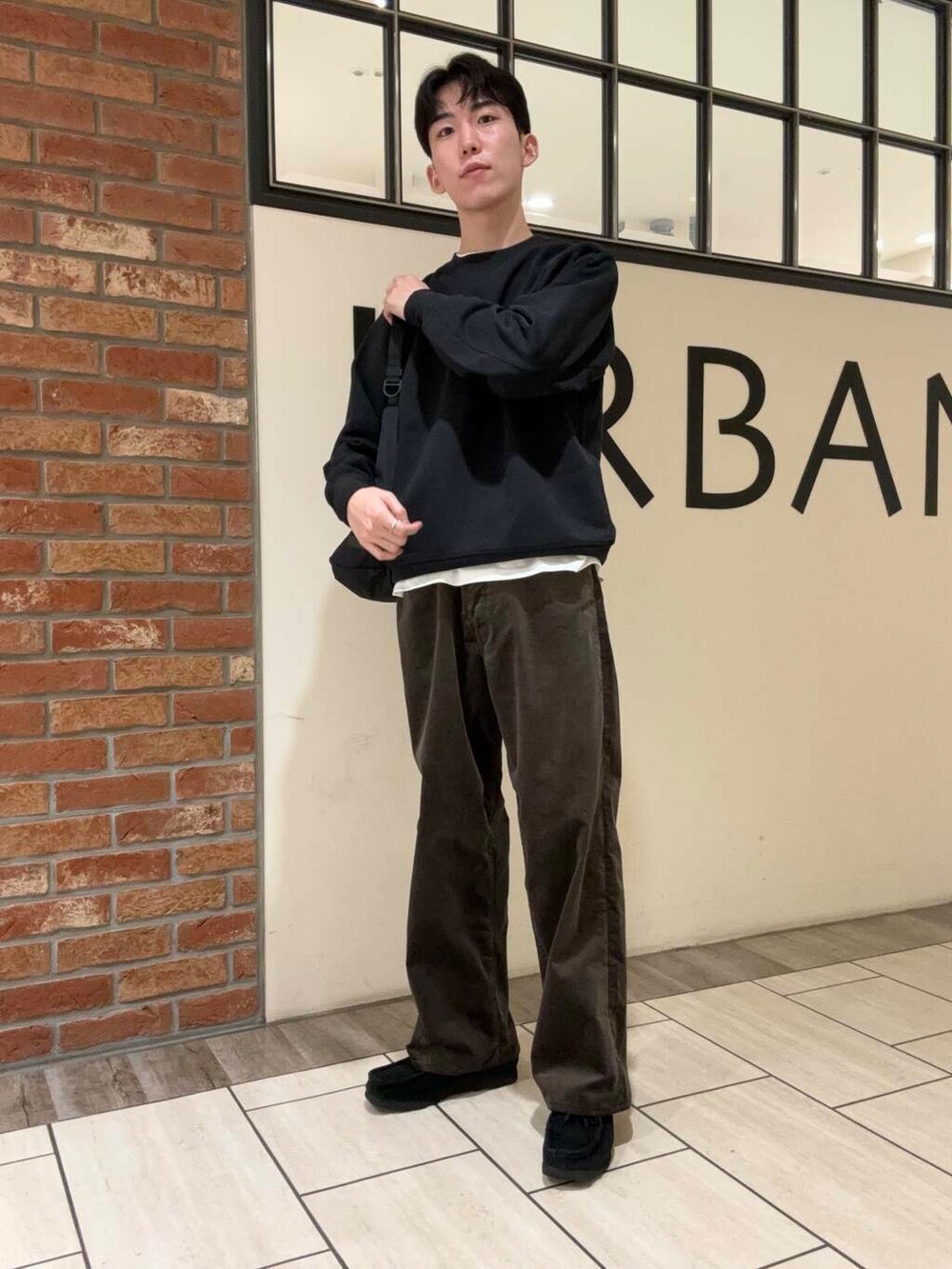 ブラック系のショルダーバッグ、ホワイト系のTシャツ/カットソー、ブラック系のその他シューズを着用したメンズの秋コーディネートの2枚目の写真