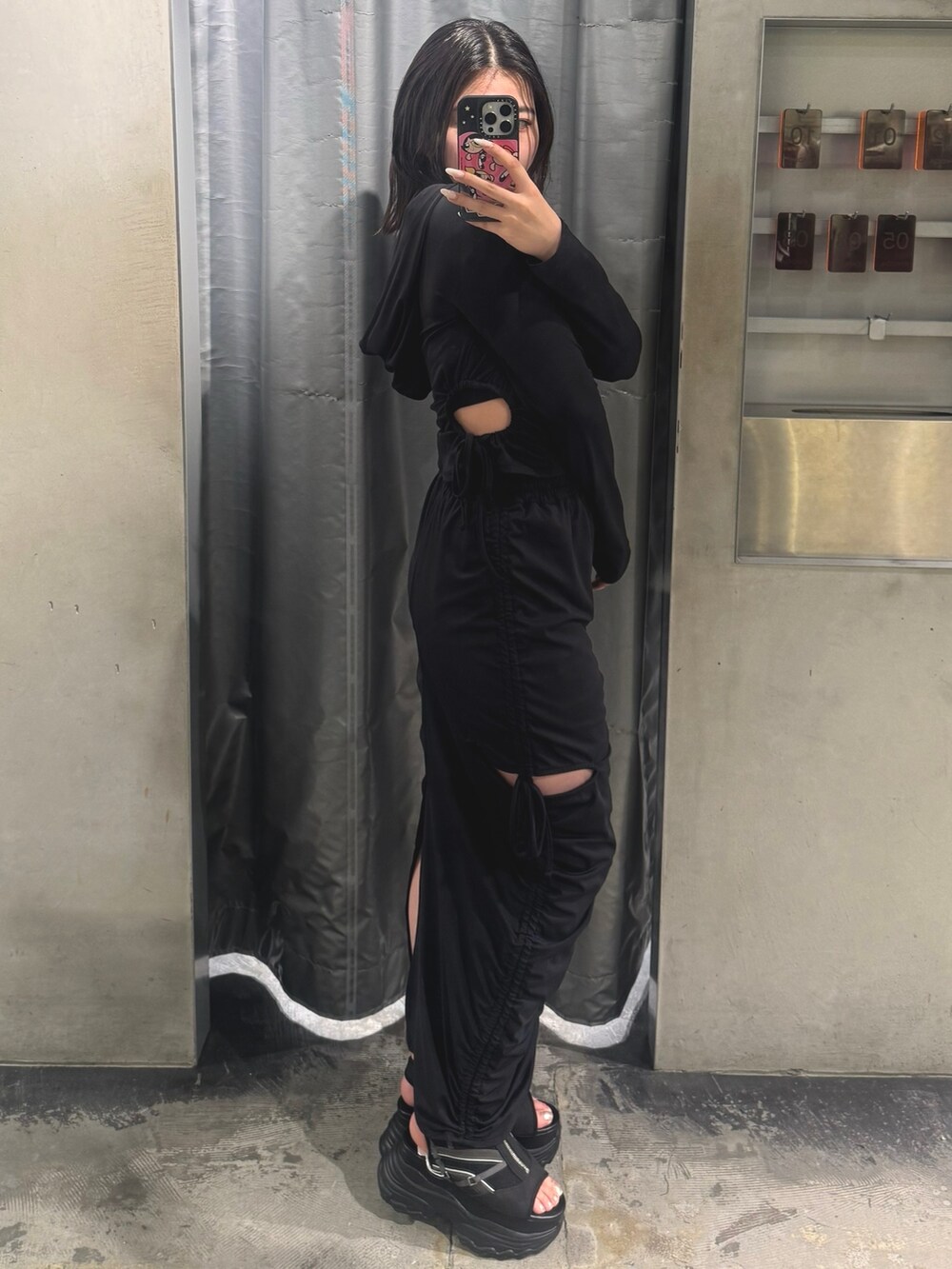 ブラック系のTシャツ/カットソー、ブラック系のスカート、ブラック系のサンダルを着用したレディースの春コーディネートの2枚目の写真