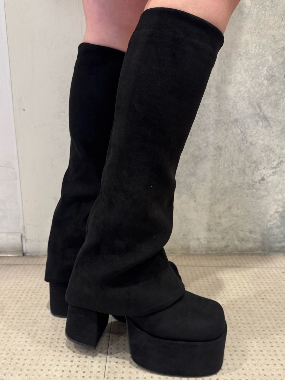 ホワイト系のデニムジャケット、ホワイト系のワンピース、ブラック系のブーツを着用したレディースの冬コーディネートの6枚目の写真