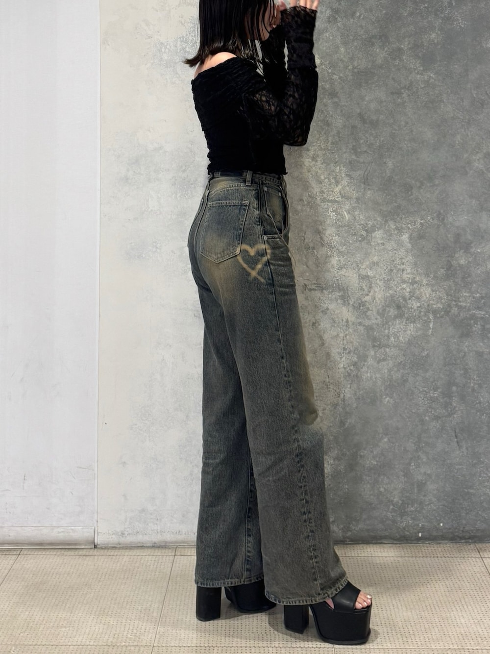 ブラック系のTシャツ/カットソー、ブルー系のデニムパンツ、ブラック系のサンダルを着用したレディースの春コーディネートの3枚目の写真