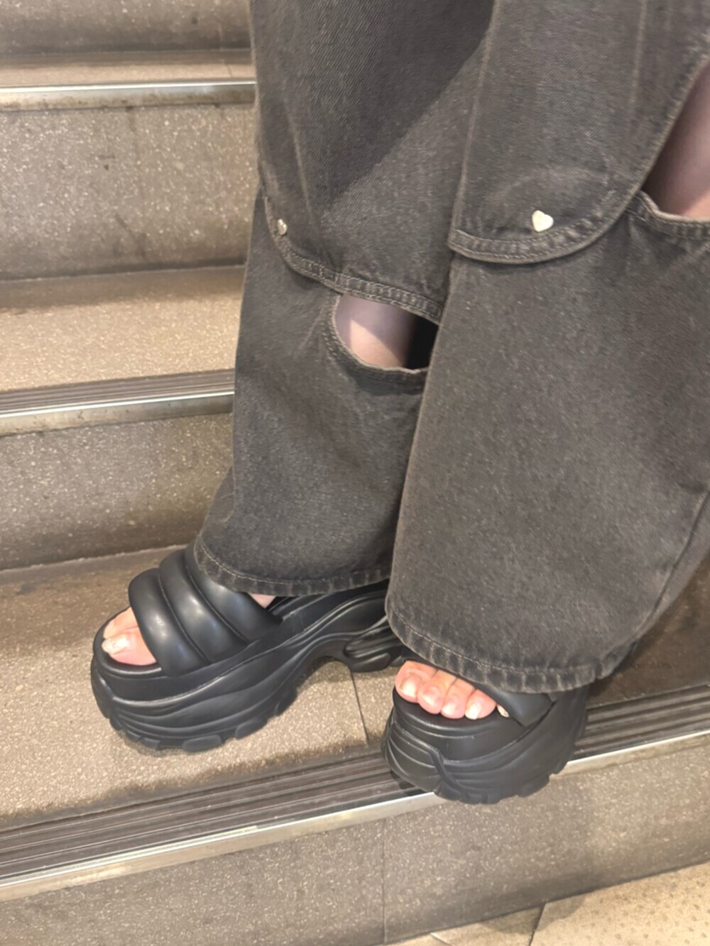 ブラック系のサンダル、ブラック系のタンクトップ、ブラック系のデニムパンツを着用したレディースの夏コーディネートの5枚目の写真