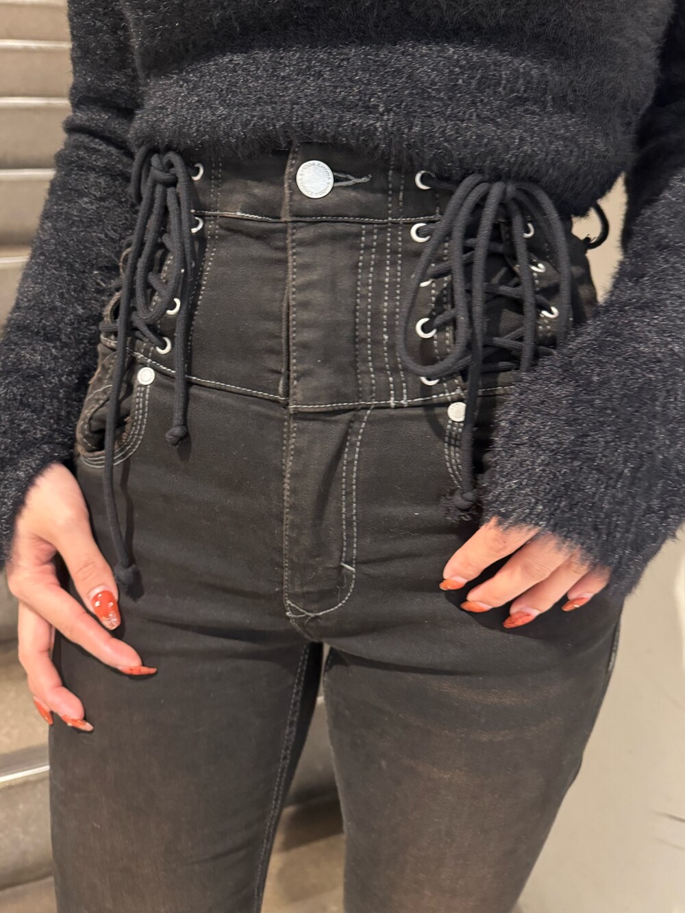 ブラウン系のダウンジャケット/コート、ブラック系のニット/セーター、ブラック系のデニムパンツを着用したレディースの冬コーディネートの4枚目の写真