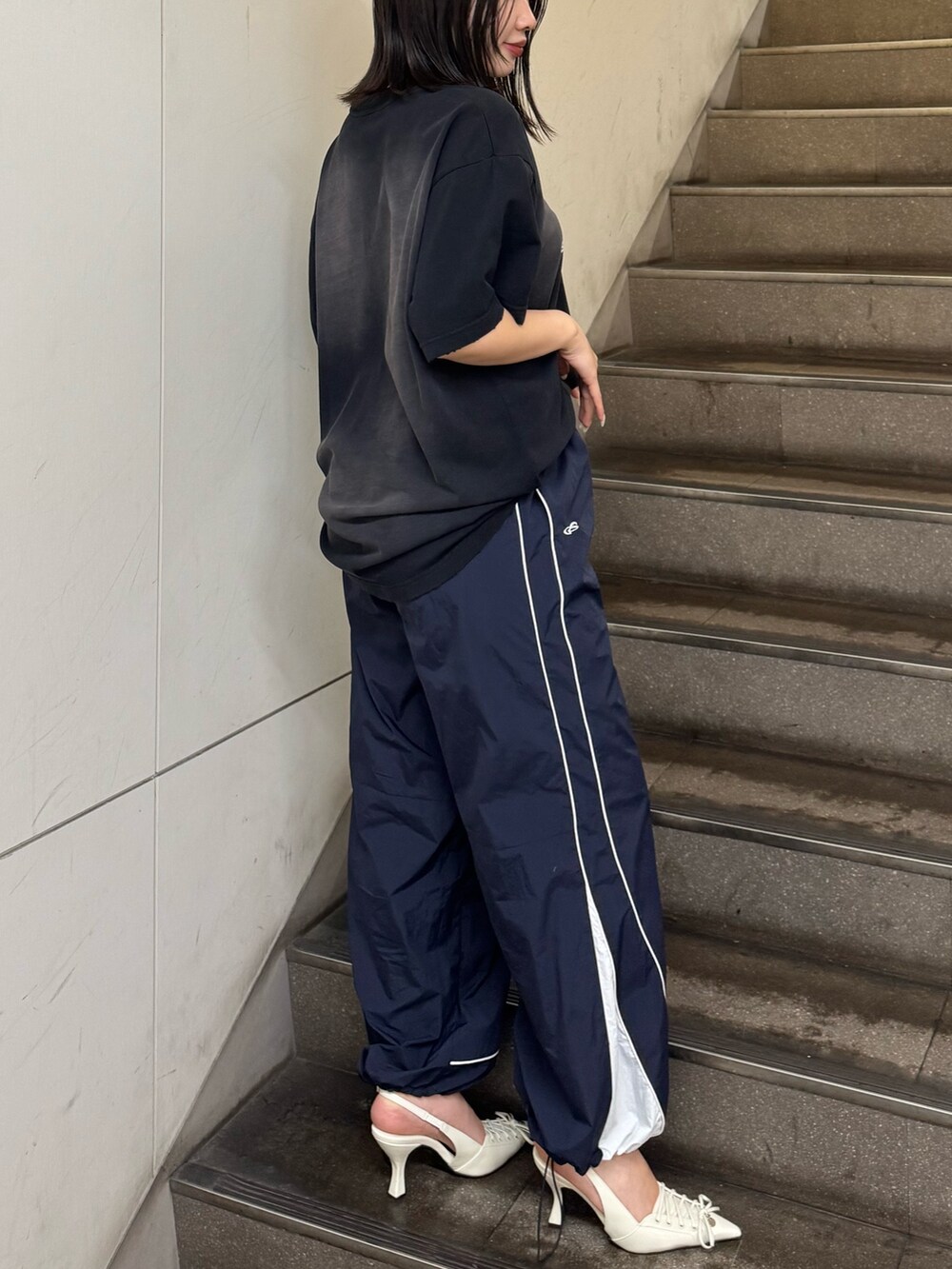 ブラック系のTシャツ/カットソー、ブルー系のその他パンツ、ホワイト系のパンプスを着用したレディースの春コーディネートの2枚目の写真