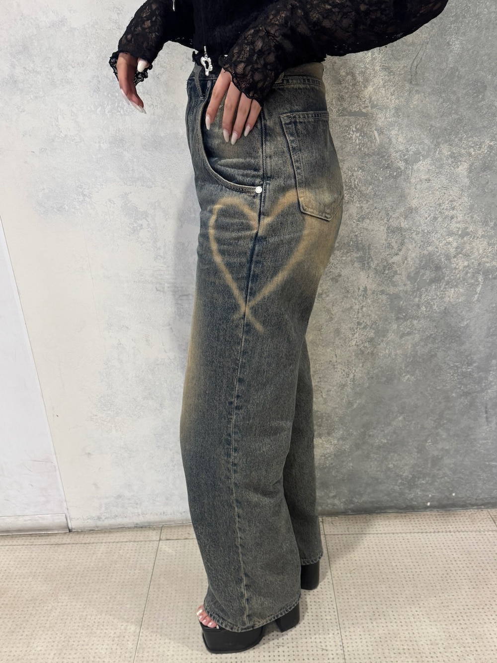 ブラック系のTシャツ/カットソー、ブルー系のデニムパンツ、ブラック系のサンダルを着用したレディースの春コーディネートの4枚目の写真