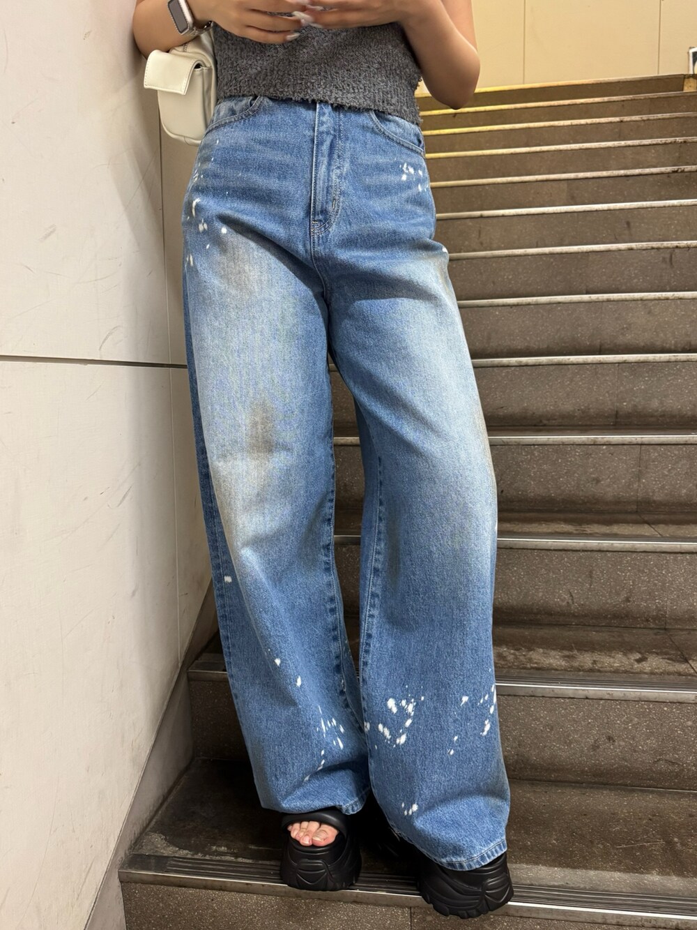 グレー系のニット/セーター、ブルー系のデニムパンツ、ブラック系のサンダルを着用したレディースの夏コーディネートの5枚目の写真