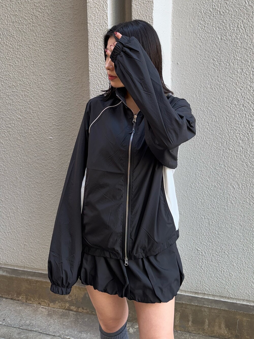 ブラック系のブルゾン、ブラック系のスカート、ブラック系のスニーカーを着用したレディースの冬コーディネートの4枚目の写真