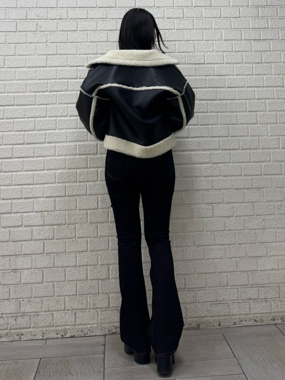 ブラック系のデニムパンツ、ブラック系のブーツ、ブラック系のブルゾンを着用したレディースの冬コーディネートの3枚目の写真