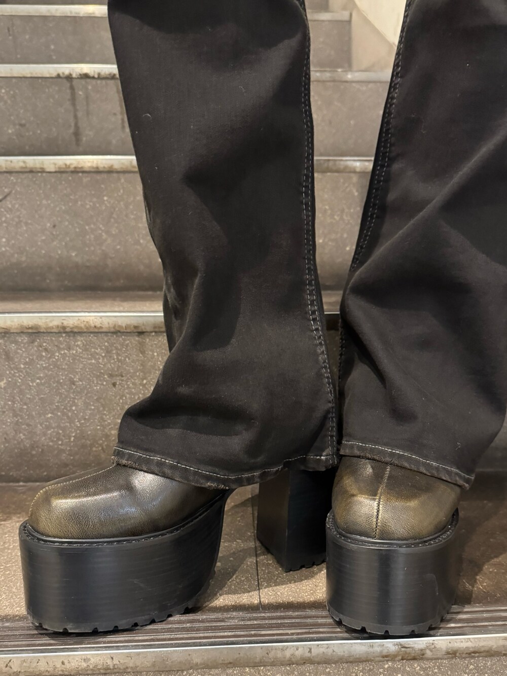 ブラウン系のダウンジャケット/コート、ブラック系のニット/セーター、ブラック系のデニムパンツを着用したレディースの冬コーディネートの5枚目の写真