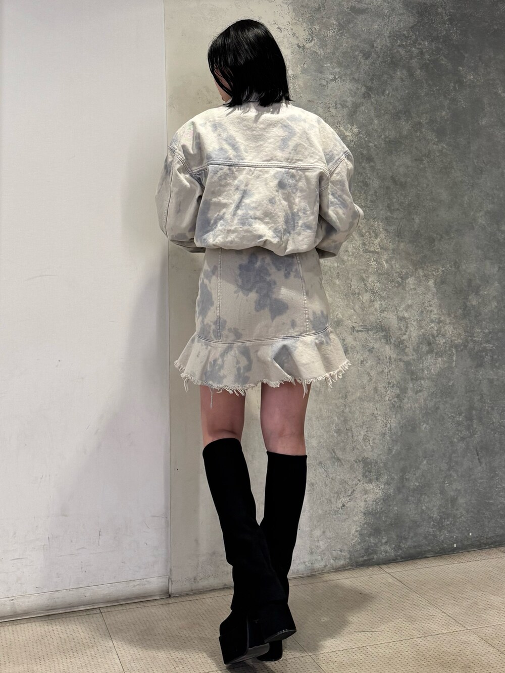 ホワイト系のデニムジャケット、ホワイト系のワンピース、ブラック系のブーツを着用したレディースの冬コーディネートの3枚目の写真