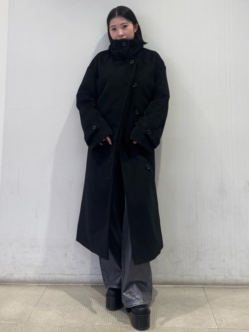 ブラック系のブーツ、シルバー系のニット/セーター、ブラック系のその他アウターを着用したレディースの冬コーディネートの2枚目の写真