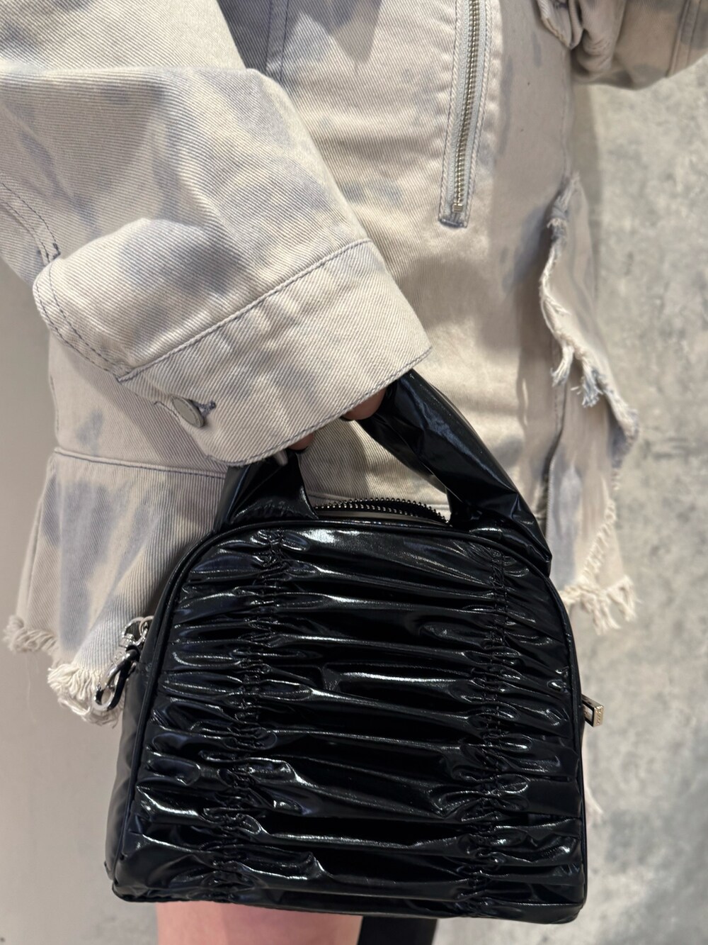 ホワイト系のデニムジャケット、ホワイト系のワンピース、ブラック系のブーツを着用したレディースの冬コーディネートの5枚目の写真