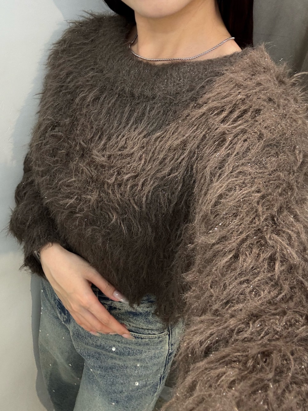 ブラウン系のニット/セーター、ブルー系のデニムパンツ、ブラック系のブーツを着用したレディースの冬コーディネートの5枚目の写真