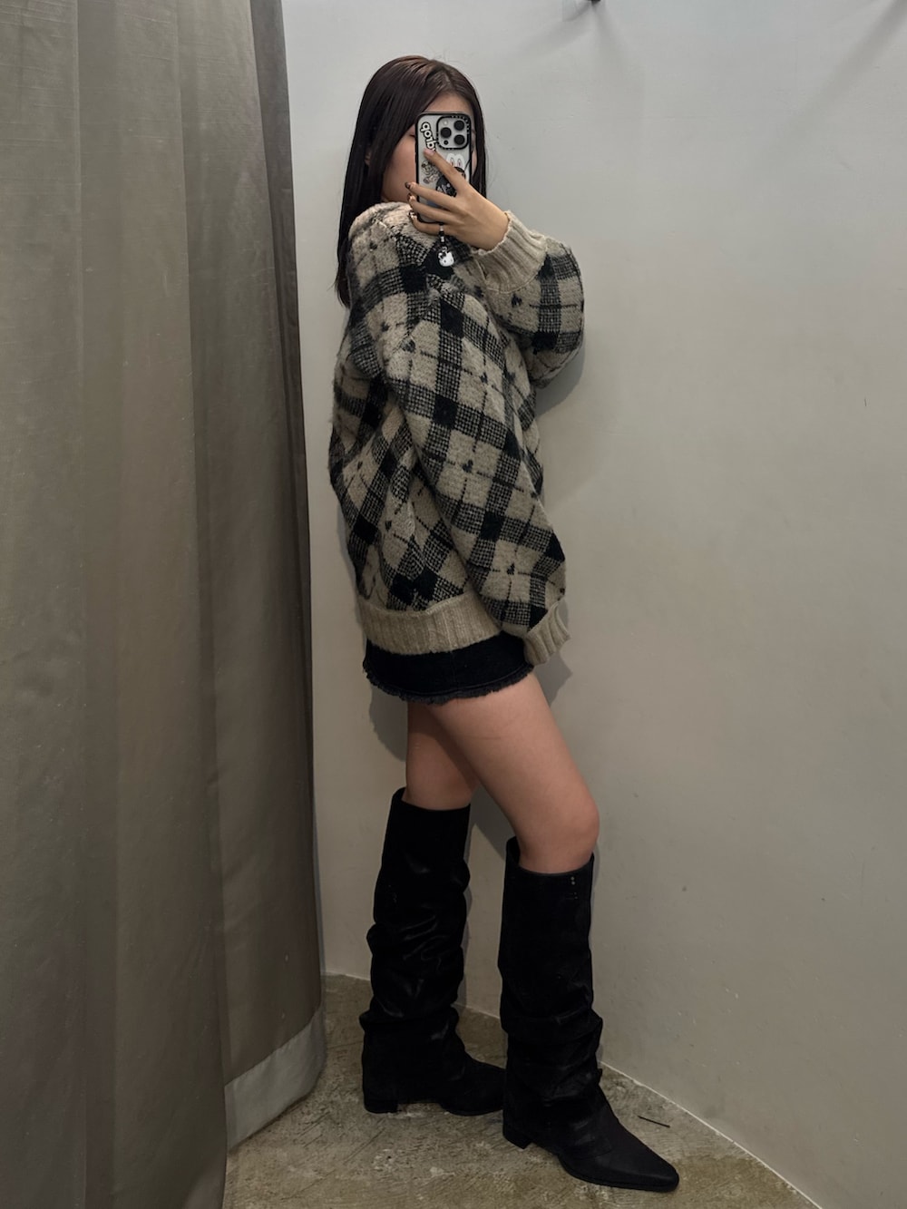 ホワイト系のニット/セーター、ブラック系のスカート、ブラック系のブーツを着用したレディースの冬コーディネートの2枚目の写真