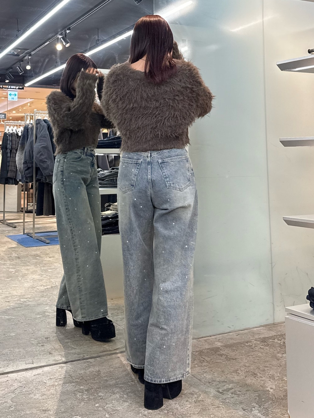 ブラウン系のニット/セーター、ブルー系のデニムパンツ、ブラック系のブーツを着用したレディースの冬コーディネートの3枚目の写真