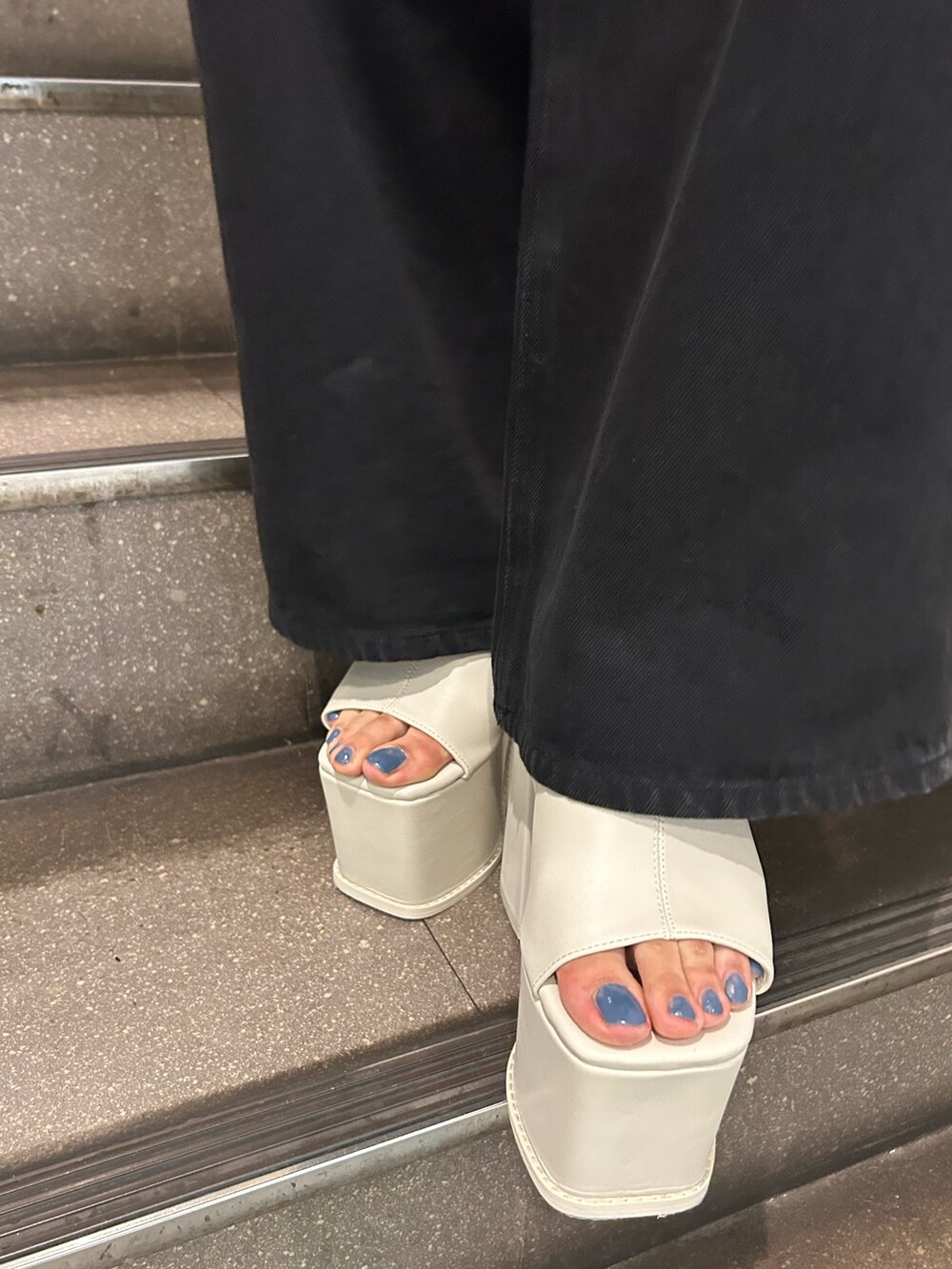 ブルー系のニット/セーター、ブラック系のデニムパンツ、ホワイト系のサンダルを着用したレディースの夏コーディネートの6枚目の写真