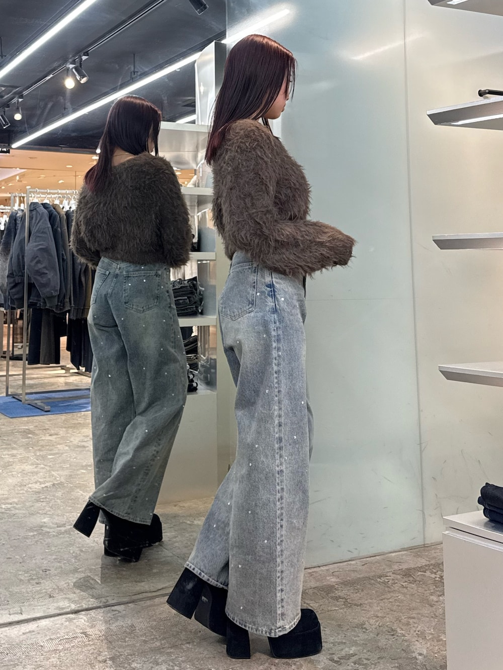 ブラウン系のニット/セーター、ブルー系のデニムパンツ、ブラック系のブーツを着用したレディースの冬コーディネートの2枚目の写真