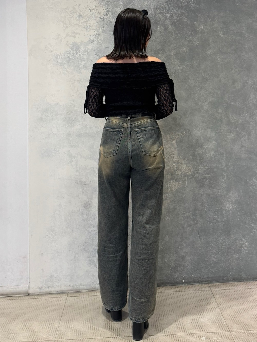 ブラック系のTシャツ/カットソー、ブルー系のデニムパンツ、ブラック系のサンダルを着用したレディースの春コーディネートの2枚目の写真