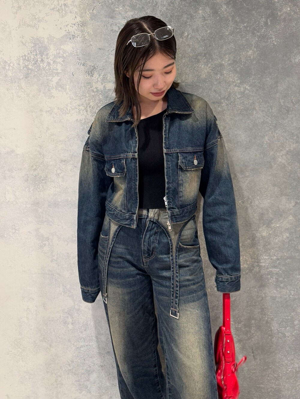 ブルー系のデニムジャケット、ブルー系のデニムパンツ、ブラック系のニット/セーターを着用したレディースの秋コーディネートの2枚目の写真