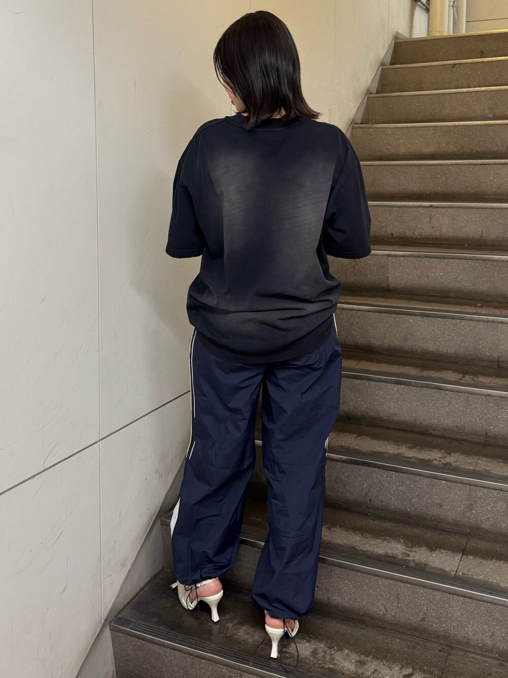 ブラック系のTシャツ/カットソー、ブルー系のその他パンツ、ホワイト系のパンプスを着用したレディースの春コーディネートの3枚目の写真