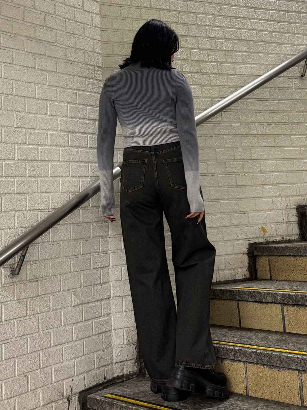 グレー系のニット/セーター、ブルー系のデニムパンツ、ブラック系のローファーを着用したレディースの冬コーディネートの3枚目の写真