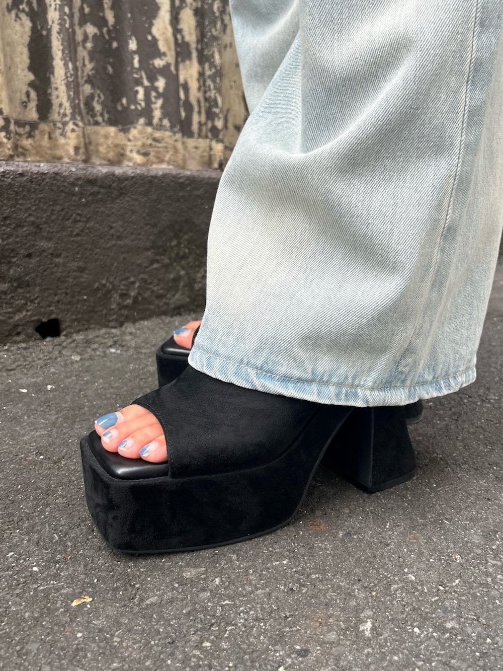 グレー系のタンクトップ、ブルー系のデニムパンツ、ブラック系のサンダルを着用したレディースの夏コーディネートの4枚目の写真