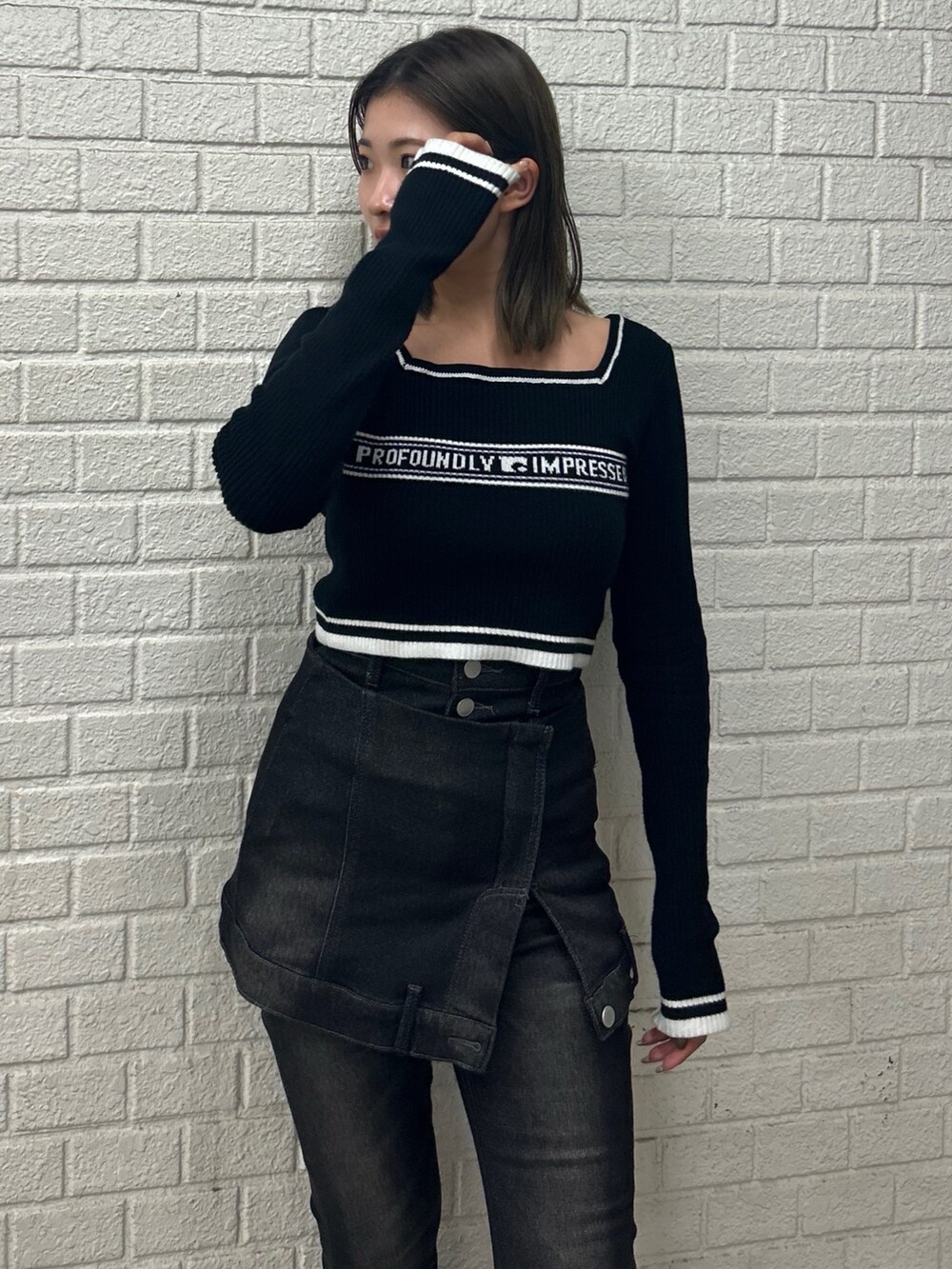 ブラック系のニット/セーター、ブラック系のデニムパンツ、ブラック系のブーツを着用したレディースの秋コーディネートの4枚目の写真