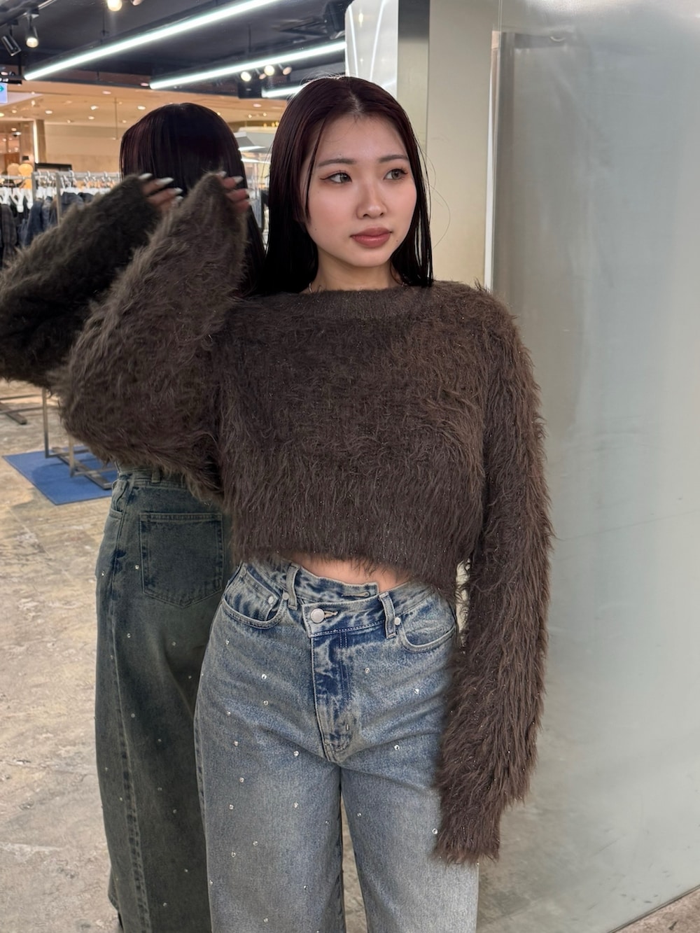 ブラウン系のニット/セーター、ブルー系のデニムパンツ、ブラック系のブーツを着用したレディースの冬コーディネートの4枚目の写真