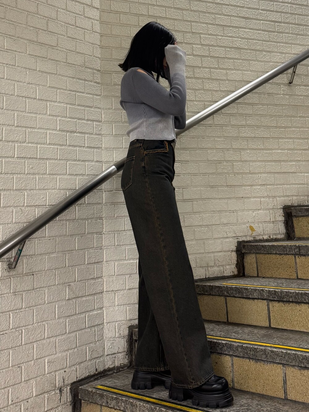 グレー系のニット/セーター、ブルー系のデニムパンツ、ブラック系のローファーを着用したレディースの冬コーディネートの2枚目の写真