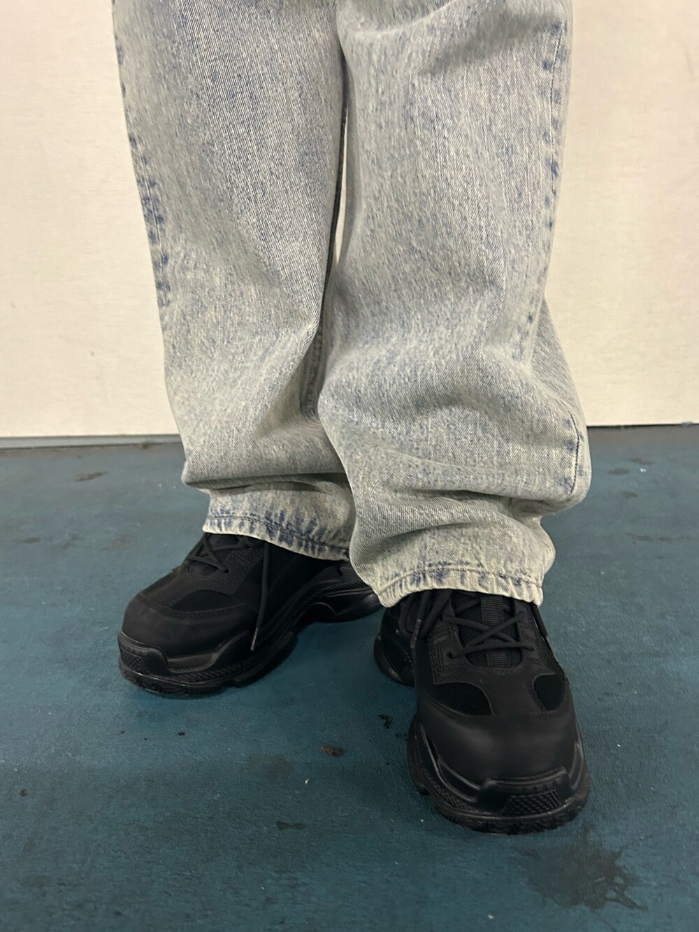 ブラック系のニット/セーター、ブルー系のデニムパンツ、ブラック系のスニーカーを着用したレディースの春コーディネートの6枚目の写真