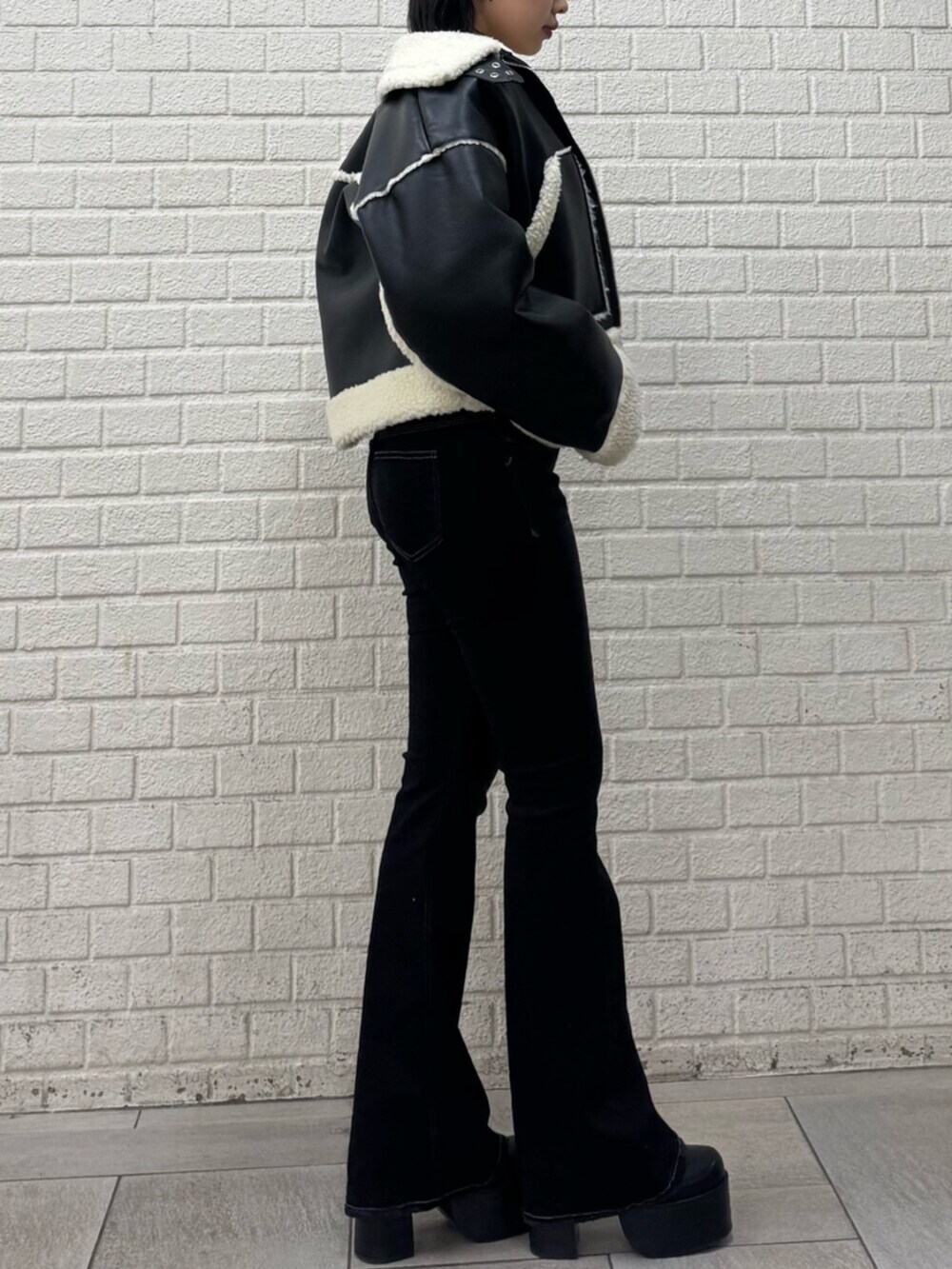 ブラック系のデニムパンツ、ブラック系のブーツ、ブラック系のブルゾンを着用したレディースの冬コーディネートの2枚目の写真