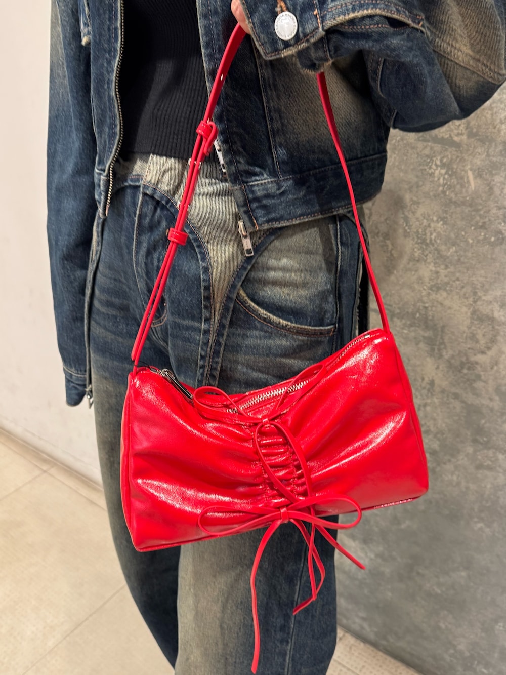 ブルー系のデニムジャケット、ブルー系のデニムパンツ、ブラック系のニット/セーターを着用したレディースの秋コーディネートの5枚目の写真