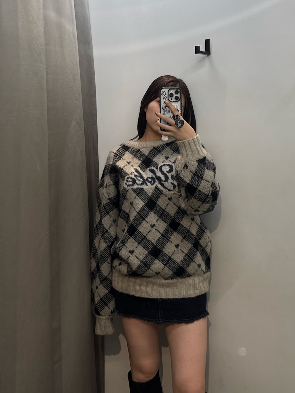 ホワイト系のニット/セーター、ブラック系のスカート、ブラック系のブーツを着用したレディースの冬コーディネートの4枚目の写真