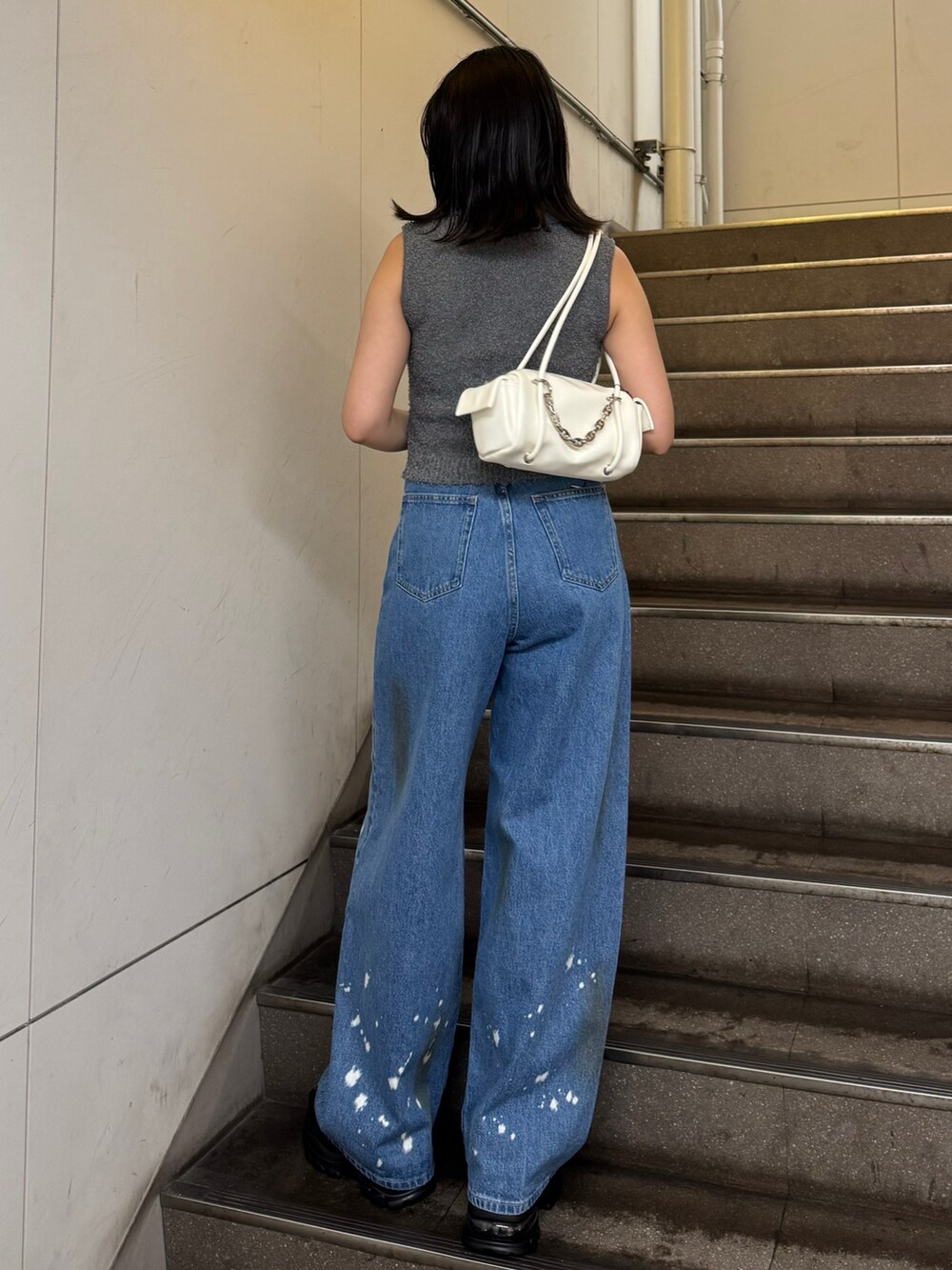 グレー系のニット/セーター、ブルー系のデニムパンツ、ブラック系のサンダルを着用したレディースの夏コーディネートの3枚目の写真