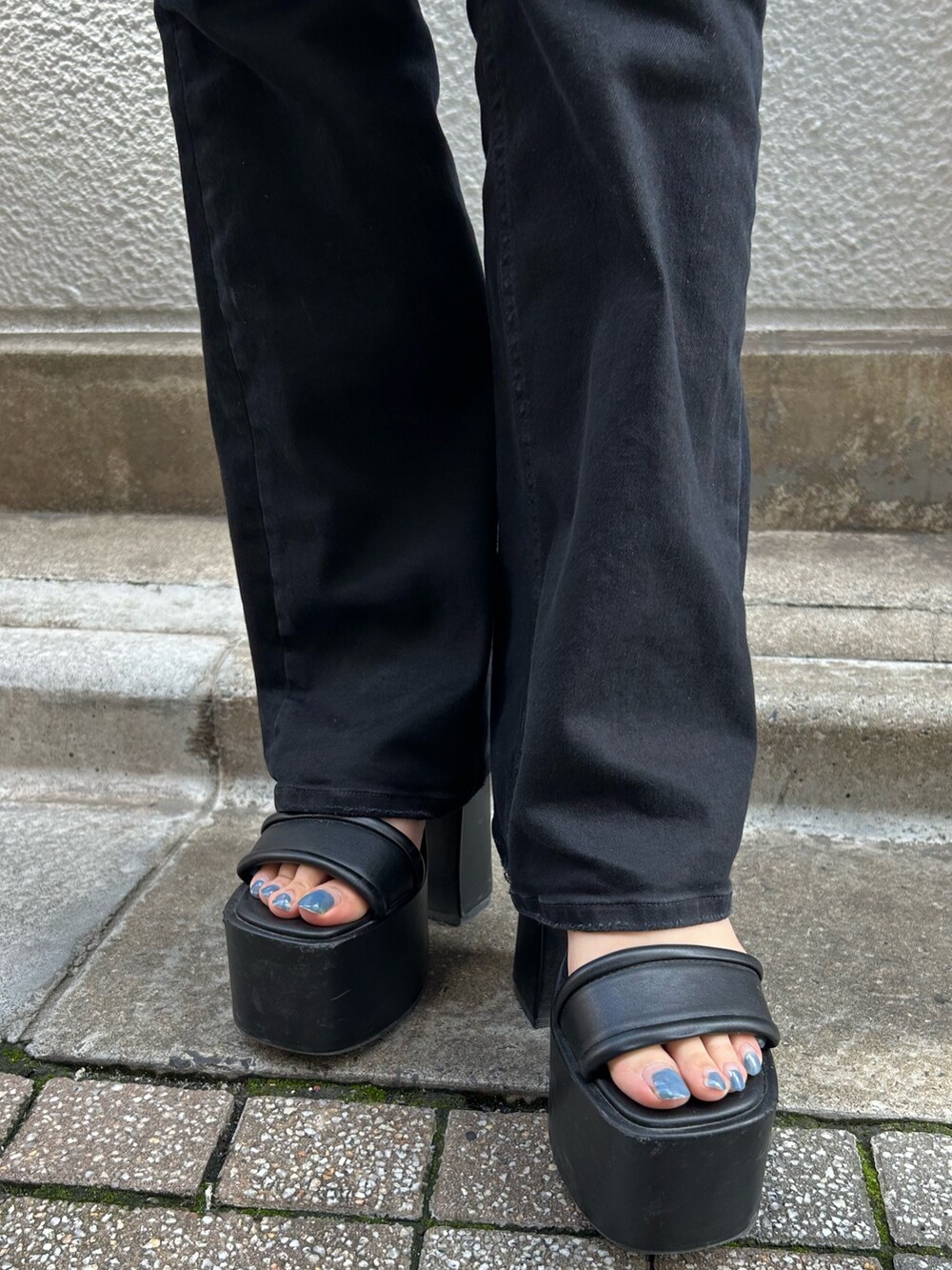 ブラック系のサロペット/オーバーオール、ブラック系のサンダル、ホワイト系のショルダーバッグを着用したレディースの春コーディネートの6枚目の写真