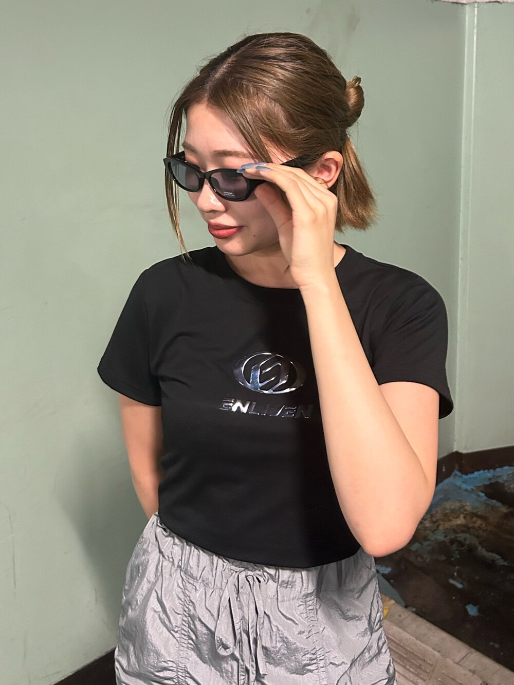 ブラック系のTシャツ/カットソー、グレー系のスカート、ブラック系のサンダルを着用したレディースの夏コーディネートの3枚目の写真