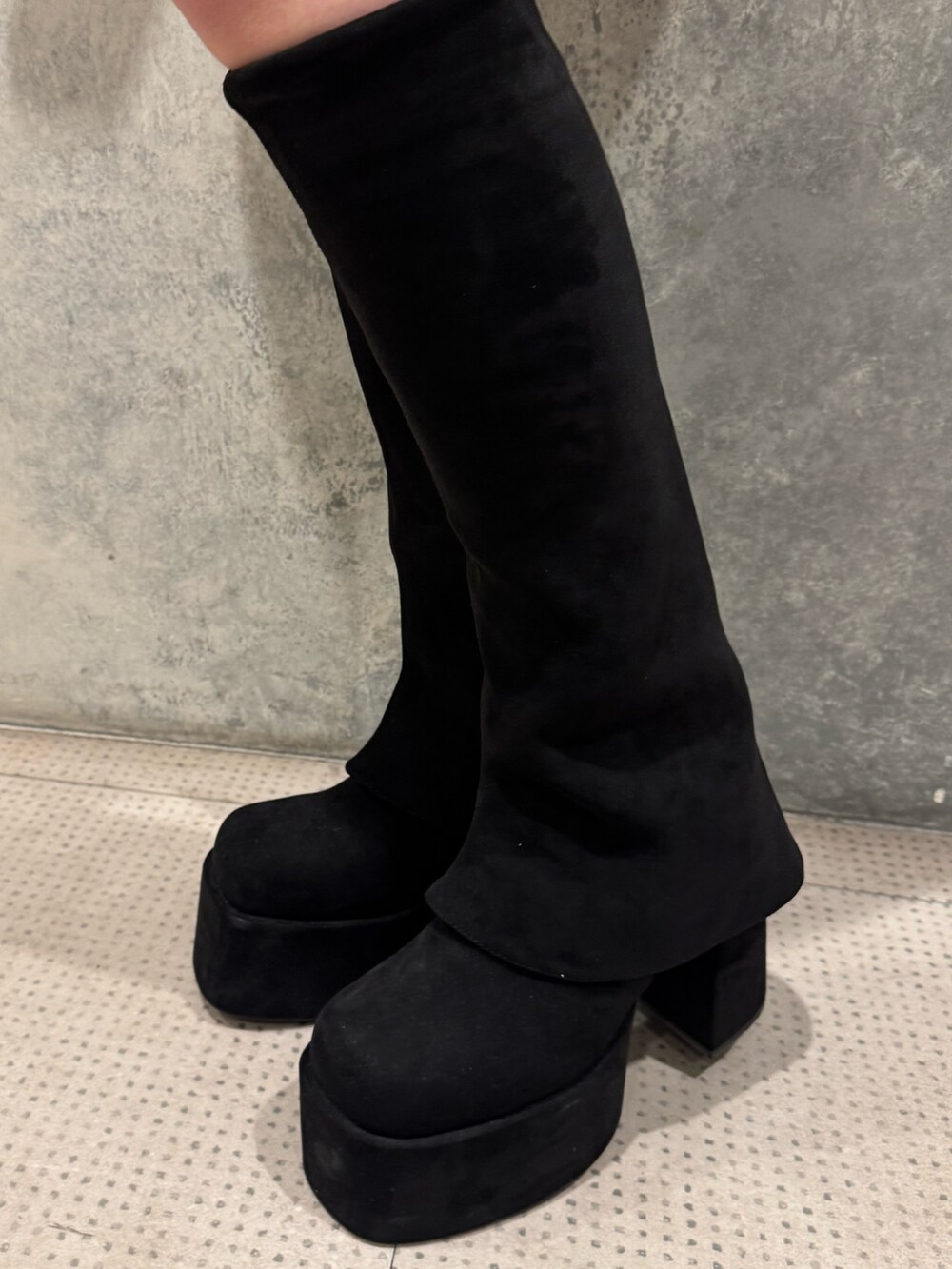 グレー系のニット/セーター、ブラック系のスカート、ブラック系のブーツを着用したレディースの秋コーディネートの5枚目の写真