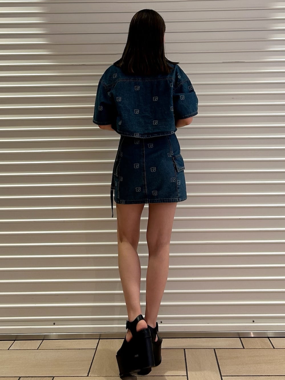 ブルー系のシャツ/ブラウス、ブルー系のデニムスカート、ブラック系のサンダルを着用したレディースの夏コーディネートの2枚目の写真