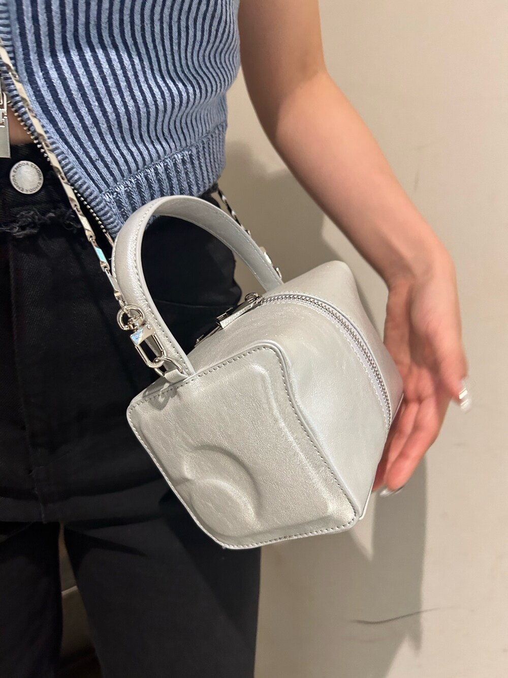 ブルー系のニット/セーター、ブラック系のデニムパンツ、ホワイト系のサンダルを着用したレディースの夏コーディネートの5枚目の写真