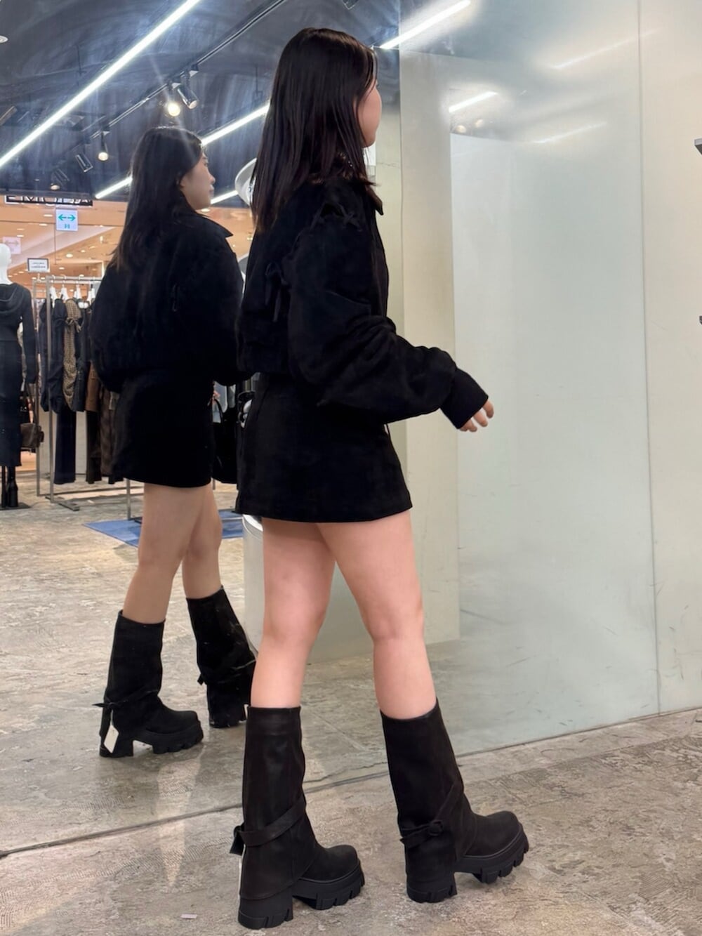 ブラック系のブーツ、ブラック系のブルゾン、ブラック系のスカートを着用したレディースの秋コーディネートの2枚目の写真