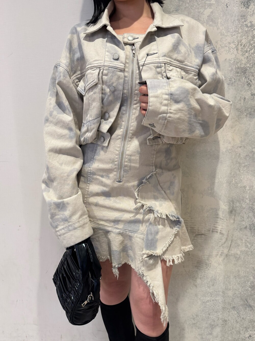 ホワイト系のデニムジャケット、ホワイト系のワンピース、ブラック系のブーツを着用したレディースの冬コーディネートの4枚目の写真