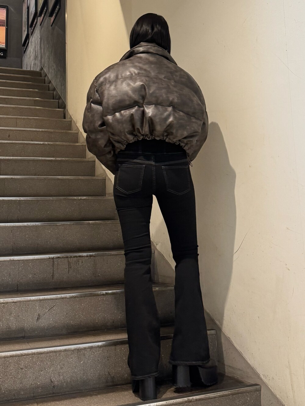 ブラウン系のダウンジャケット/コート、ブラック系のニット/セーター、ブラック系のデニムパンツを着用したレディースの冬コーディネートの3枚目の写真