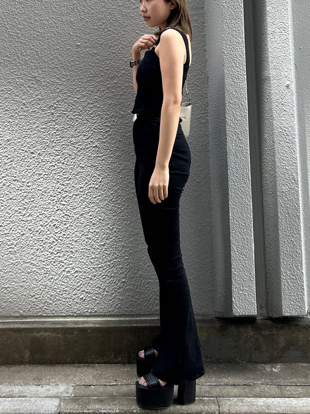 ブラック系のサロペット/オーバーオール、ブラック系のサンダル、ホワイト系のショルダーバッグを着用したレディースの春コーディネートの3枚目の写真