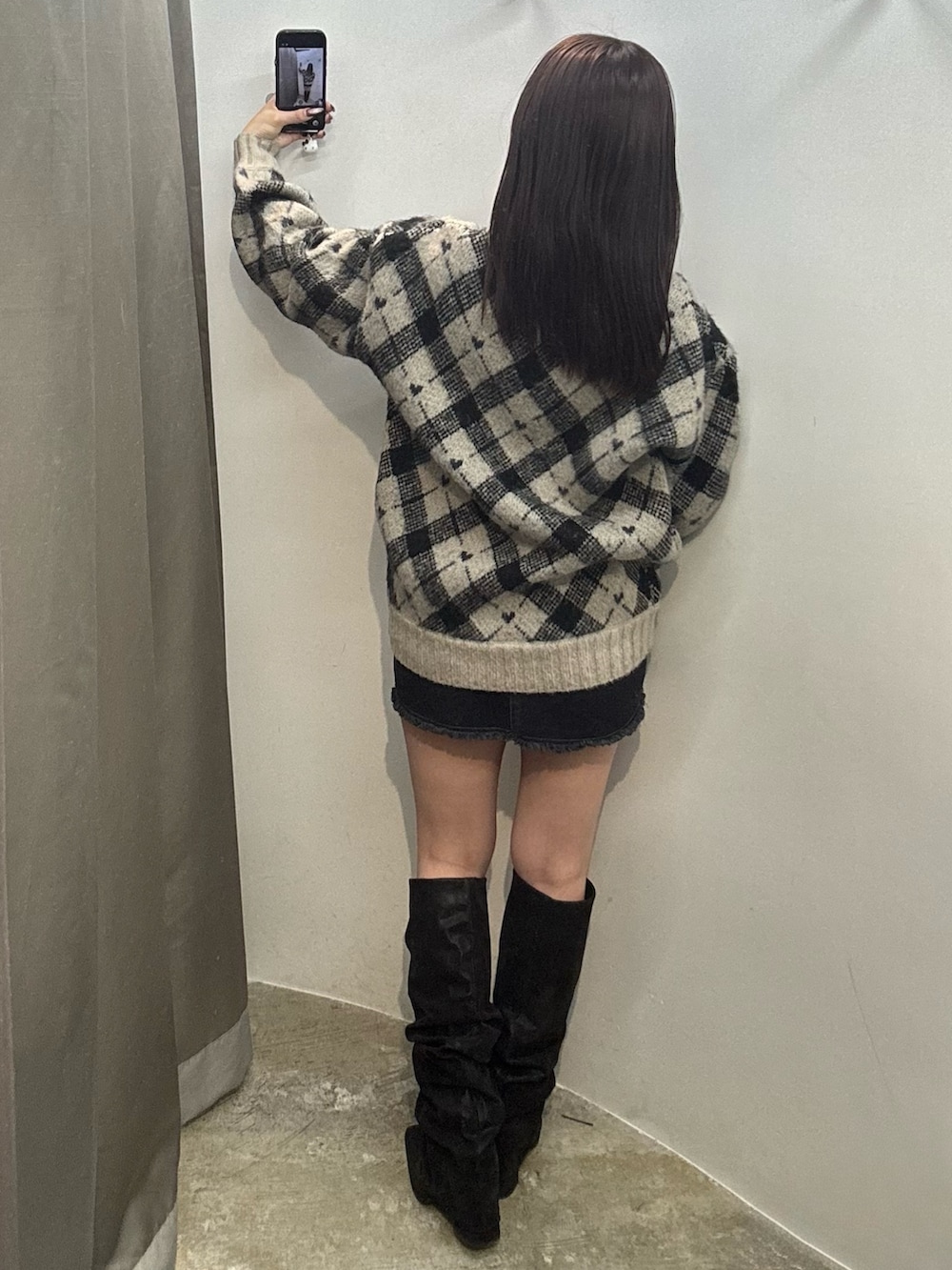 ホワイト系のニット/セーター、ブラック系のスカート、ブラック系のブーツを着用したレディースの冬コーディネートの3枚目の写真