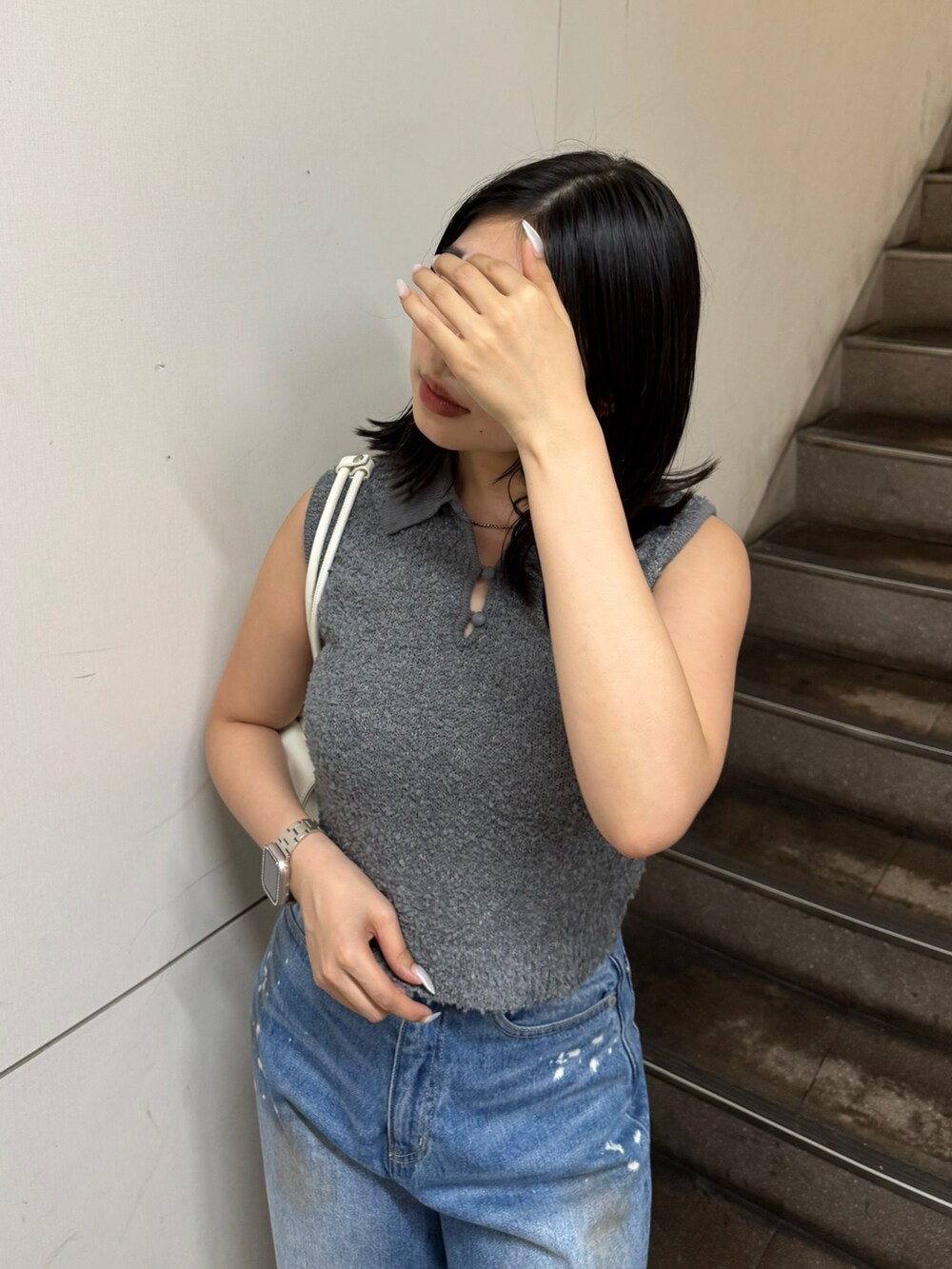 グレー系のニット/セーター、ブルー系のデニムパンツ、ブラック系のサンダルを着用したレディースの夏コーディネートの4枚目の写真