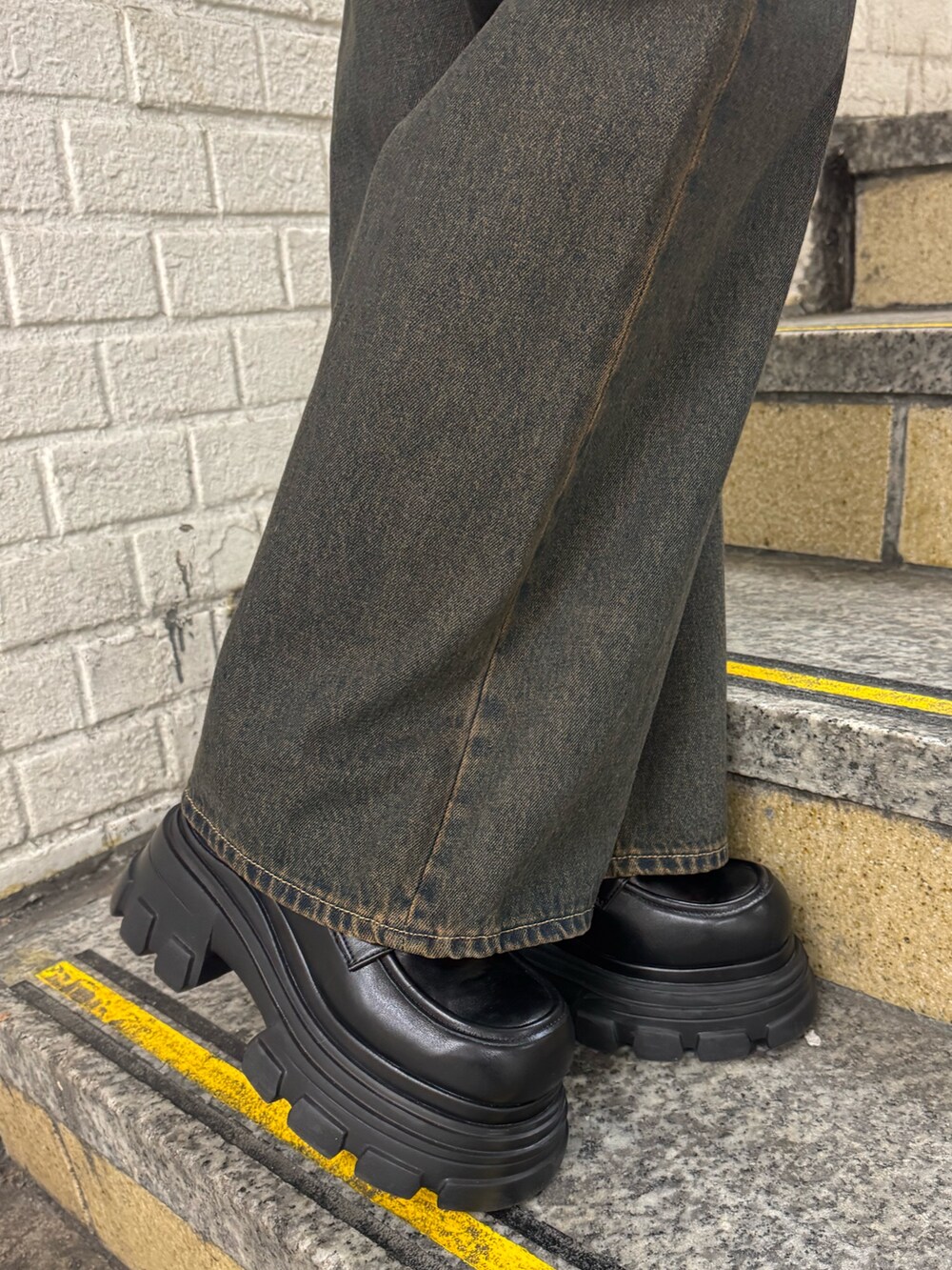 グレー系のニット/セーター、ブルー系のデニムパンツ、ブラック系のローファーを着用したレディースの冬コーディネートの4枚目の写真