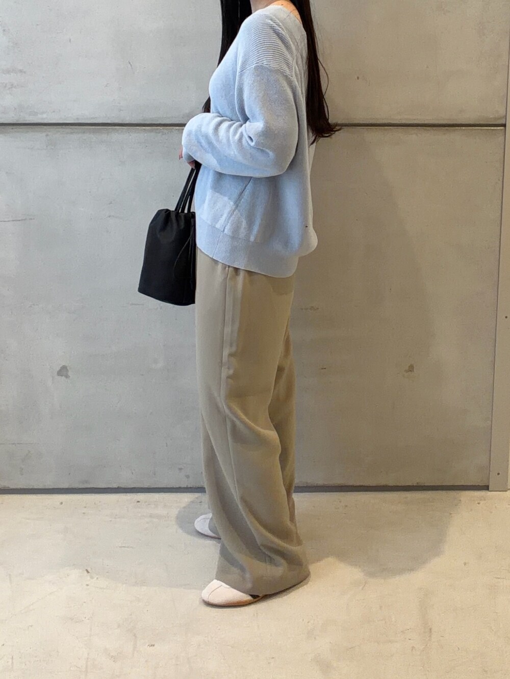 ブルー系のニット/セーター、ベージュ系のその他パンツ、ホワイト系のスニーカーを着用したレディースの春コーディネートの3枚目の写真