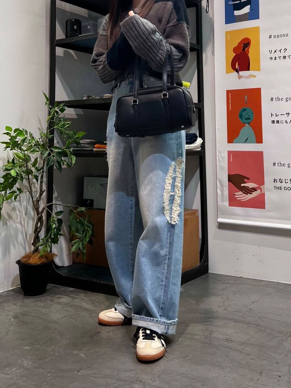ベージュ系のスニーカー、ブラック系のボストンバッグ、ブルー系のデニムパンツを着用したレディースの夏コーディネートの3枚目の写真